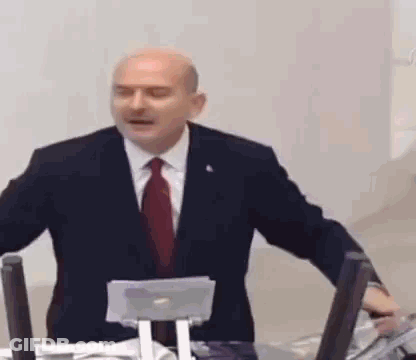Man In Suit Giving Speech At Microphone GIF