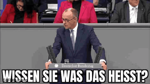 Man In Suit Giving Speech At Podium GIF