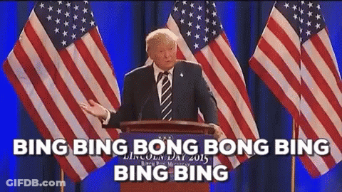 Man In Suit Giving Speech At Podium With American Flags GIF