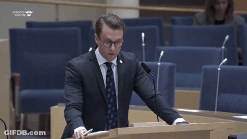 Man In Suit Giving Speech At Sveriges Riksdag Podium GIF
