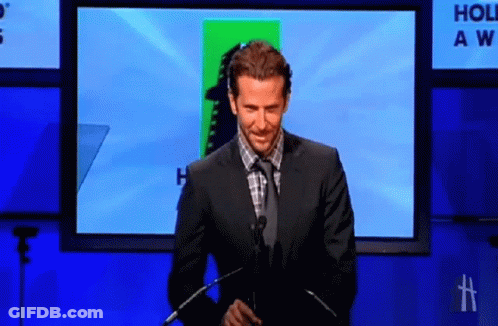 Man In Suit Giving Speech In Front Of Holiday Awards Screen GIF