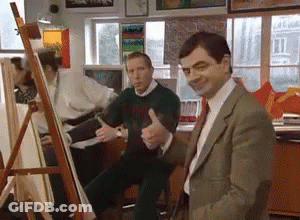 Man In Suit Giving Thumbs Up In Front Of Easel GIF