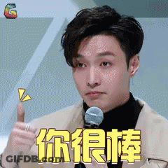 Man In Suit Giving Thumbs Up In Front Of Microphone With Chinese Writing GIF