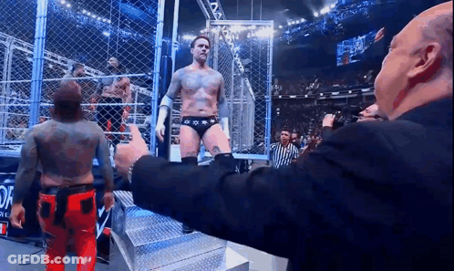 Man In Suit Giving Thumbs Up To Wrestler GIF