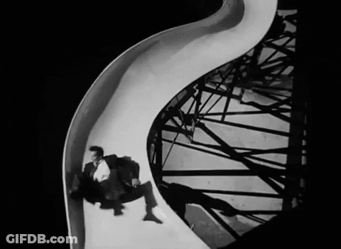 Man In Suit Going Down Slide Black And White GIF
