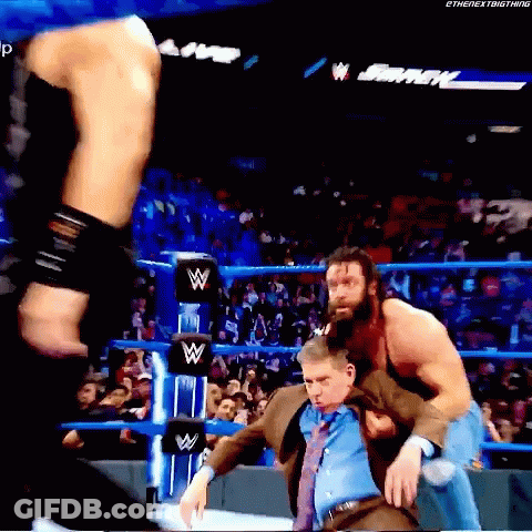 Man In Suit Held By Wrestler In Match GIF