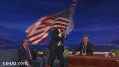 Man In Suit Holding American Flag Before Full Moon GIF
