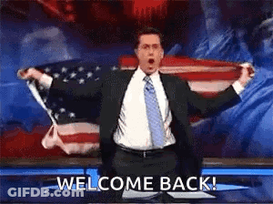Man In Suit Holding American Flag Saying Welcome Back GIF