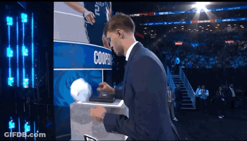 Man In Suit Holding Basketball In Front Of Cooper Sign GIF