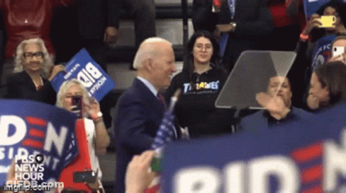 Man In Suit Holding Biden Sign GIF