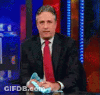 Man In Suit Holding Blue Object GIF