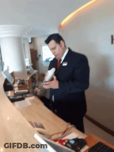 Man In Suit Holding Book At Counter GIF