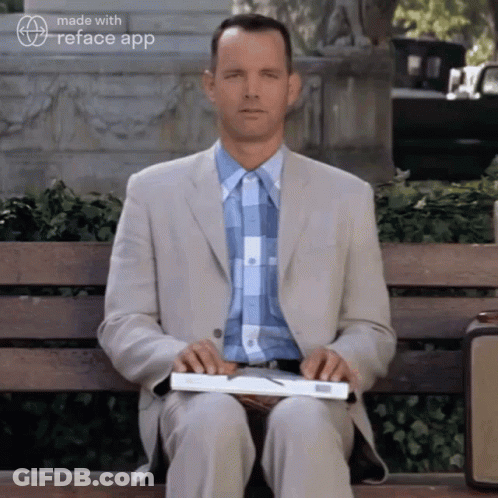 Man In Suit Holding Book On Bench GIF