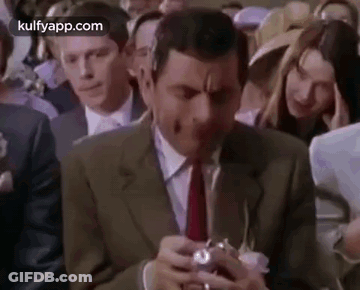 Man In Suit Holding Camera In Crowd GIF