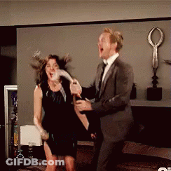 Man In Suit Holding Champagne Woman In Black Dress Holding Wine GIF