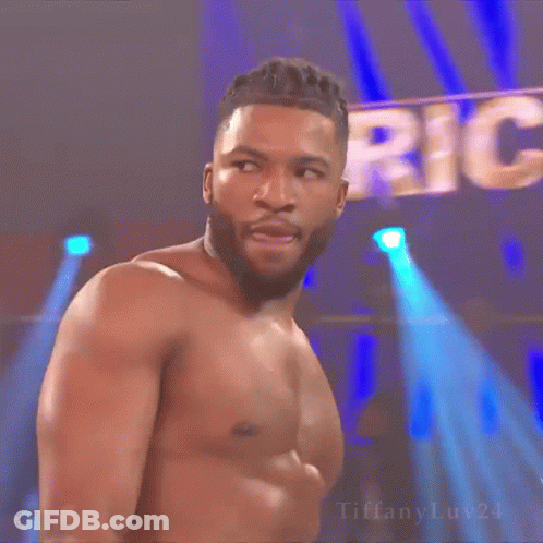 Man In Suit Holding Championship Belt With Another Man Behind GIF