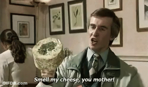 Man In Suit Holding Cheese Says Smell My Cheese You Mother GIF