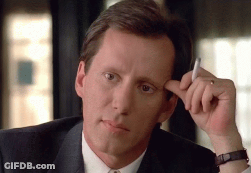 Man In Suit Holding Cigarette To Forehead GIF