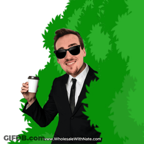 Man In Suit Holding Coffee Behind Green Bush GIF