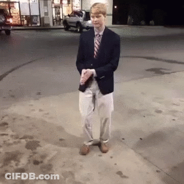 Man In Suit Holding Coffee On Sidewalk GIF