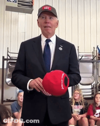 Man In Suit Holding Donald Trump Hat GIF