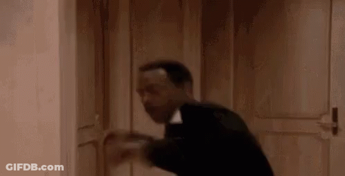 Man In Suit Holding Door Open In Hallway GIF