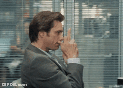 Man In Suit Holding Finger To Nose GIF
