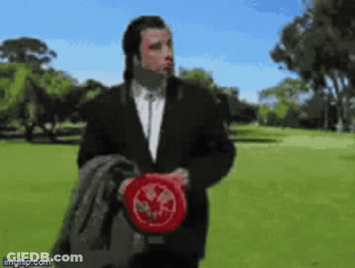Man In Suit Holding Frisbee In Park GIF