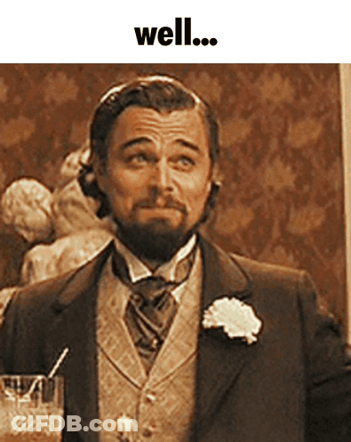 Man In Suit Holding Glass With Straw Saying Well GIF
