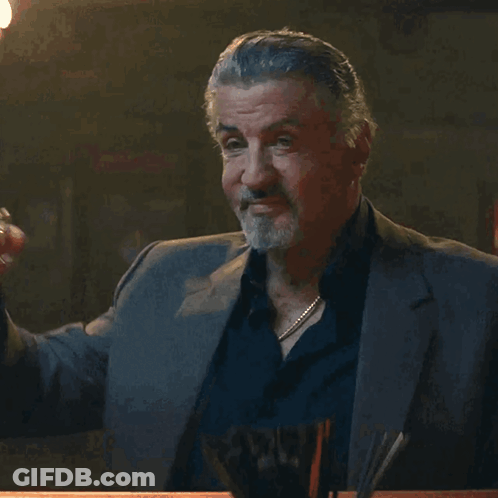 Man In Suit Holding Glass GIF