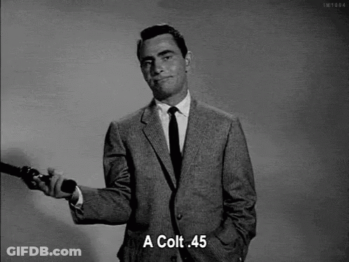 Man In Suit Holding Gun And Saying Colt 45 GIF