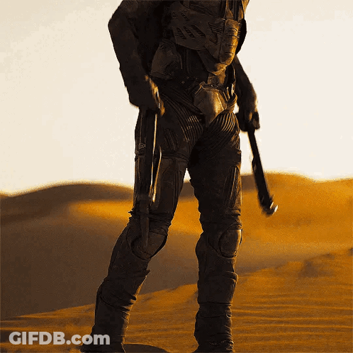 Man In Suit Holding Gun In Desert GIF