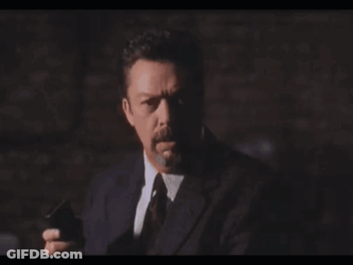 Man In Suit Holding Gun Saying Heavy Breath Again GIF