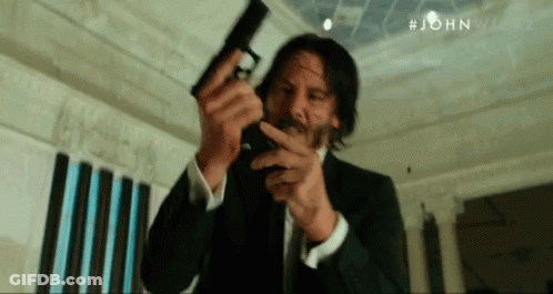 Man In Suit Holding Gun GIF
