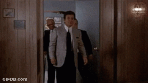 Man In Suit Holding Gun To Ear GIF