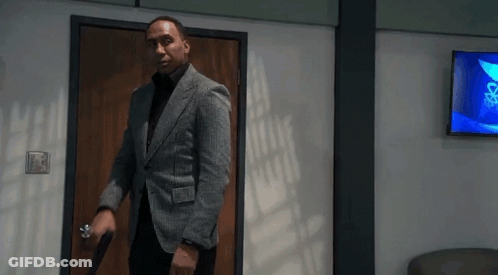 Man In Suit Holding Gun Walking Through Doorway GIF