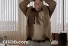 Man In Suit Holding Hands To Head By Window GIF