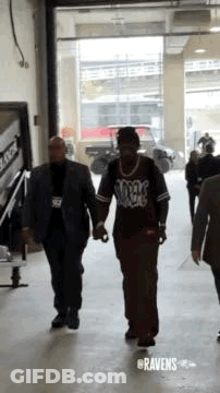 Man In Suit Holding Hands With Security Guard GIF