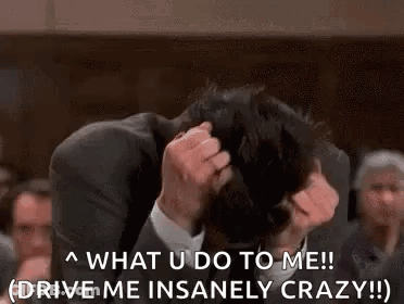 Man In Suit Holding Head Crowd Watches GIF