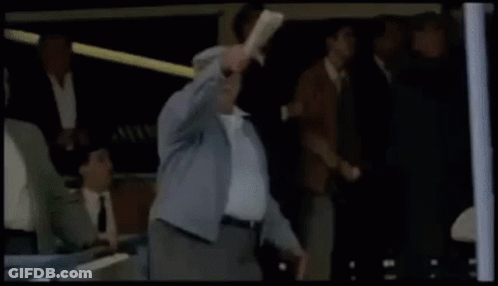 Man In Suit Holding Head In Front Of Crowd GIF
