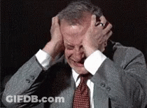 Man In Suit Holding Head In Pain GIF