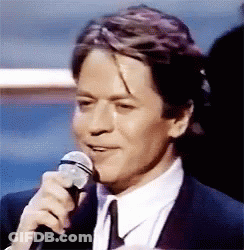 Man In Suit Holding Microphone GIF