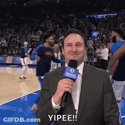 Man In Suit Holding Microphone Basketball Court Yipee GIF