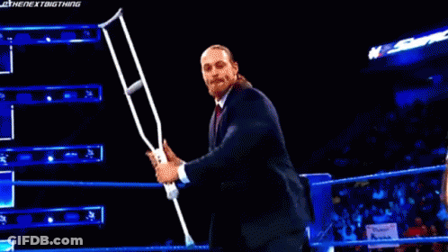 Man In Suit Holding Microphone In Wrestling Ring GIF
