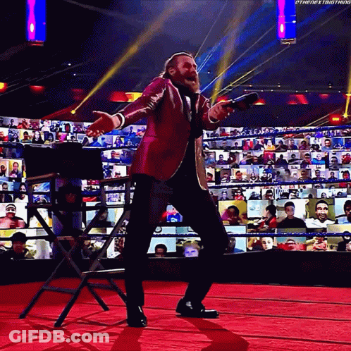 Man In Suit Holding Microphone On Red Carpet GIF