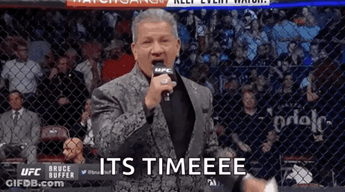 Man In Suit Holding Microphone Says Timeee GIF
