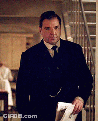 Man In Suit Holding Paper In Front Of Stairs GIF