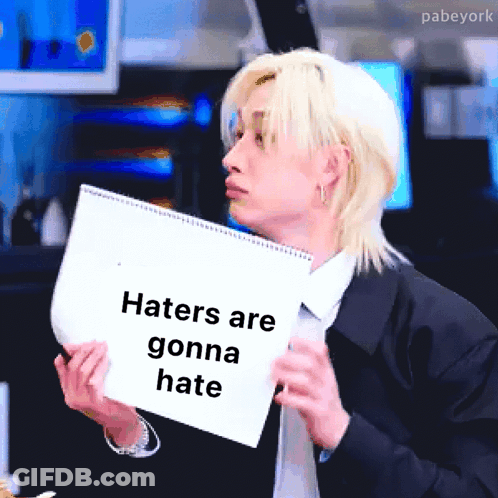 Man In Suit Holding Paper Says Haters Are Gonna Hate GIF
