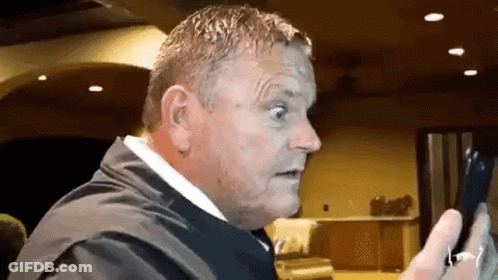 Man In Suit Holding Phone Making Funny Face GIF