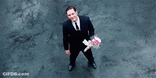 Man In Suit Holding Pink Flowers GIF